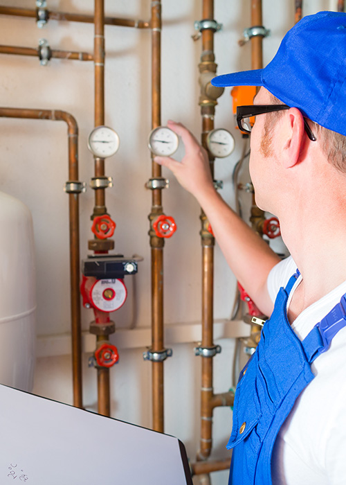 Installateur notiert Messwerte von Heizungsanlage